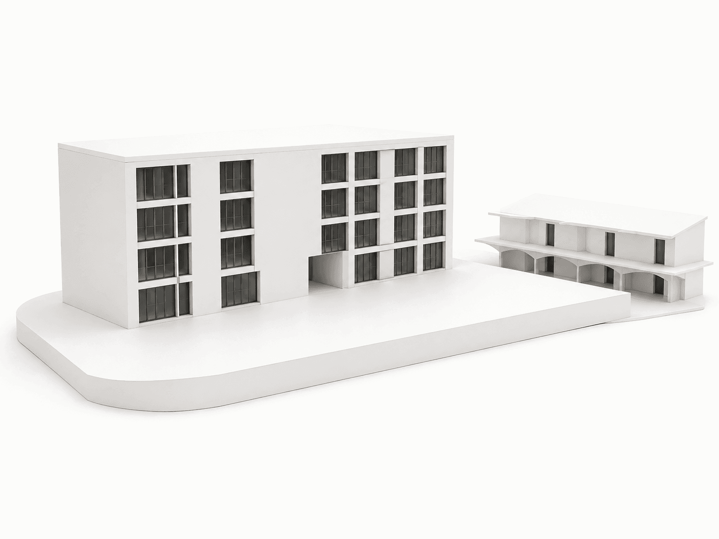 A maqueta do conjunto em branco: o bloco principal e o edifício baixo com arcada, sobre a plataforma do lote.
